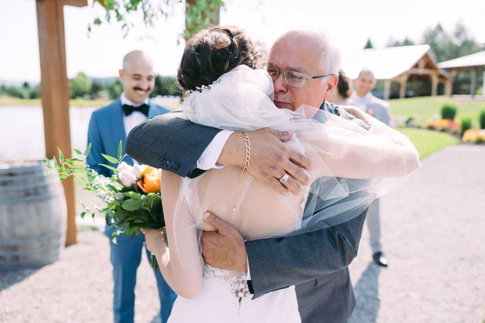 father of bride hugging bride at wedding ceremony in Naples, NY