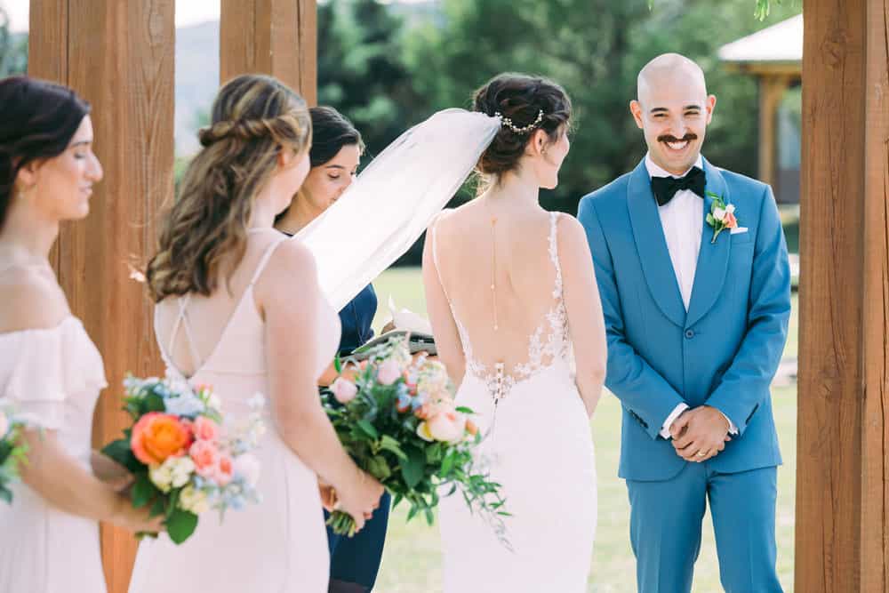 groom smiling at bride during wedding ceremony at Wren's Roost Barn wedding.